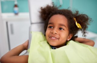 Portrait of satisfied child in dental chair after successful dental treatment pediatric dentistry dentist in Oxnard California